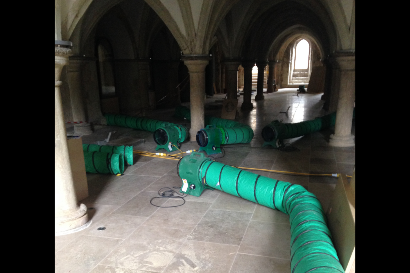 4 VENTEX® Axial 300P Fans directing air to two rows of ducting on the floor of a water storage tank