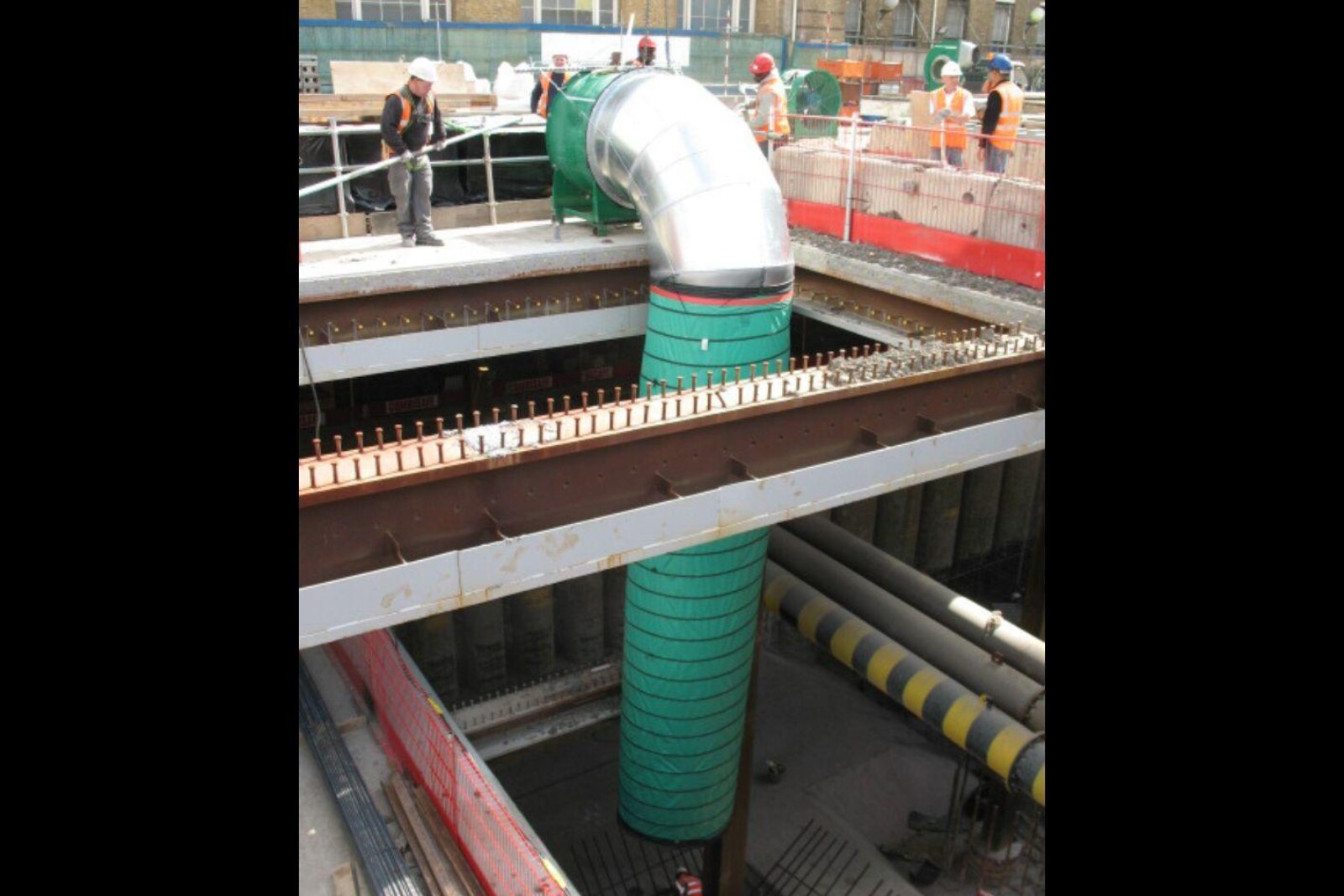 VENTEX Axial Fan 1250S on the floor with ducting hanging over the edge to provide fresh air to the basement and works taking place below ground level