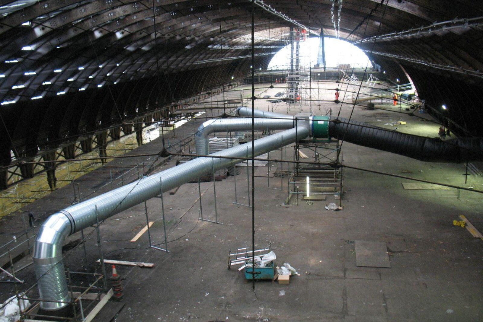 VENTEX Axial Fan 1250S with 3 metal ductwork attachments providing airflow through 3 square holes in the ceiling to the railway station below