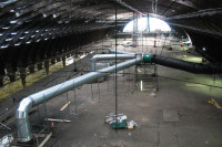 VENTEX Axial Fan 1250S with 3 metal ductwork attachments providing airflow through 3 square holes in the ceiling to the railway station below