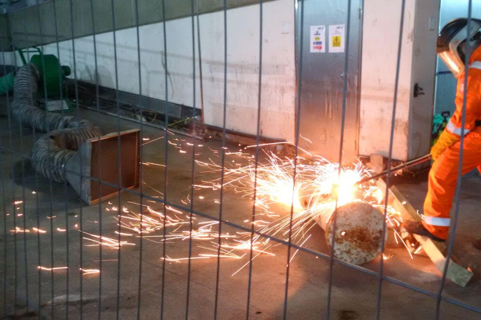 VENTEX Centrifugal Fan 300M making up part of a fume extraction system whilst a nearby rail worker performs steel cutting with hot sparks coming from the works