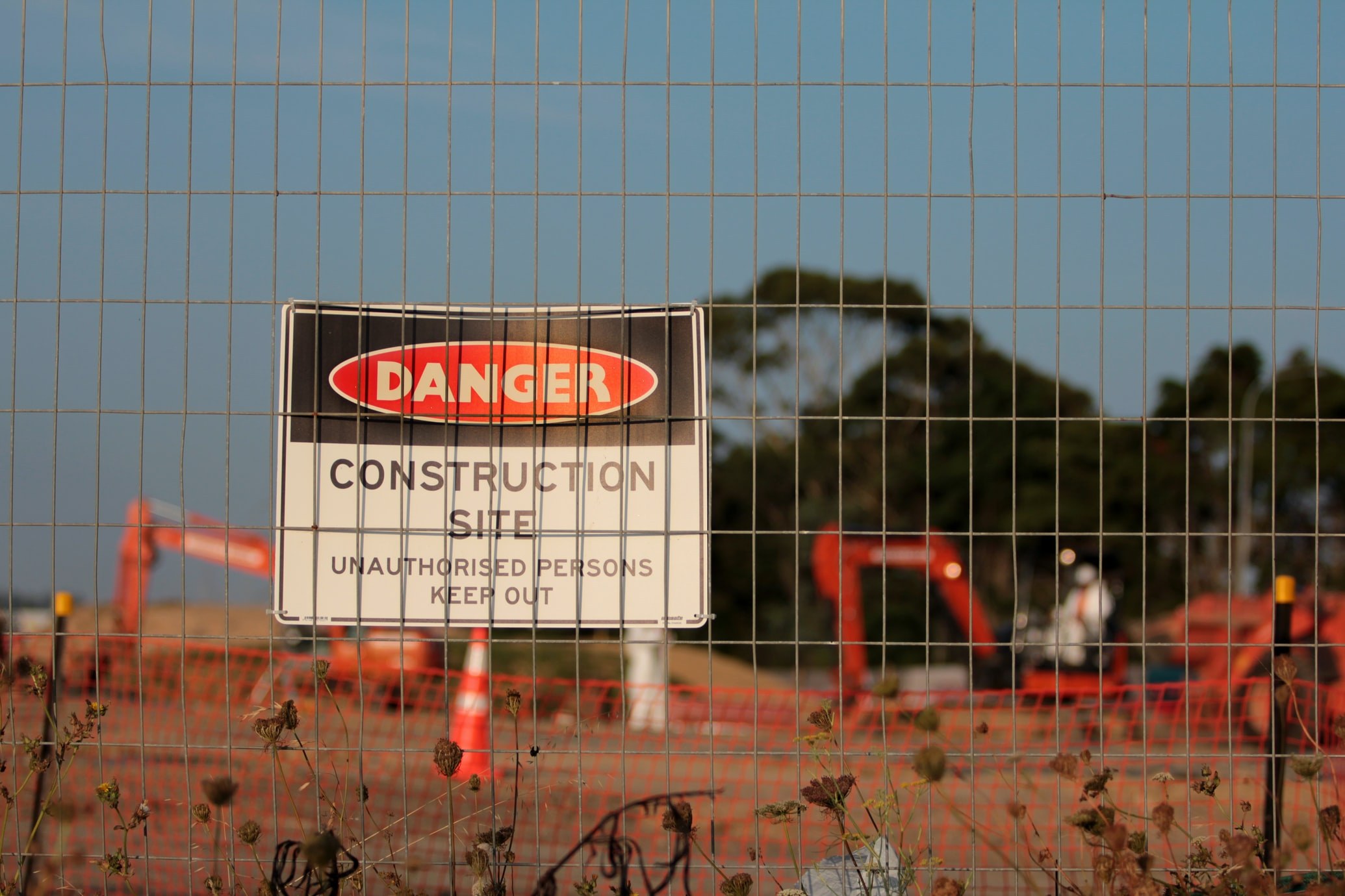 Danger sign behind construction site fence